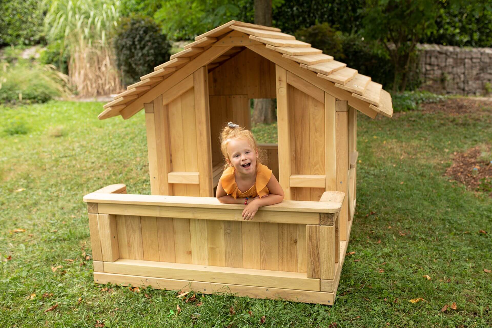 Kind im baumann + trapp Spielhaus Robinchen mit Terrasse
