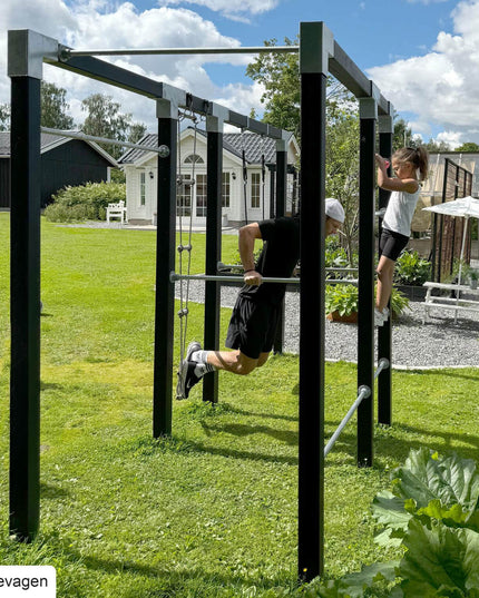 Mann und Kind turnen auf dem Plus Outdoor Fitness Trainingsgestell - Modell 3.