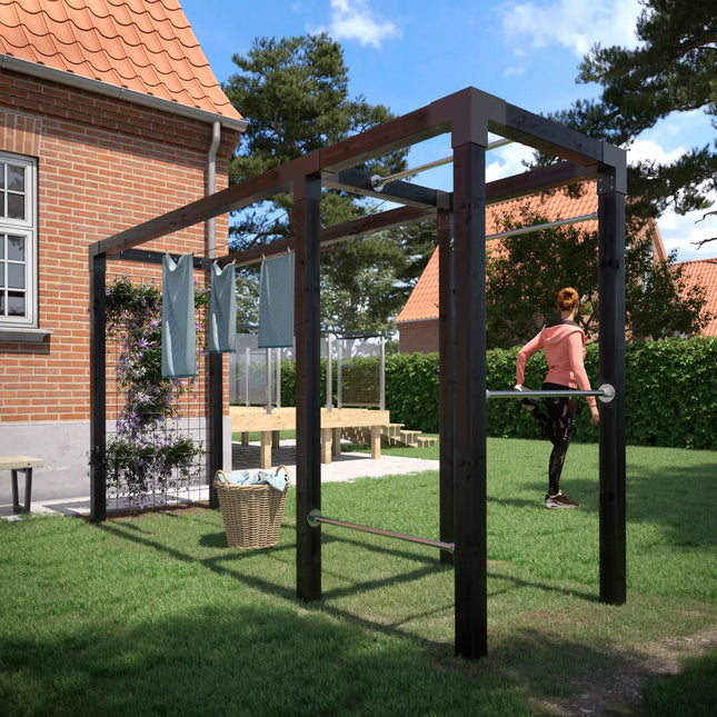 Daylife Trockengestell mit Fitnessmodul und Spalier im Garten neben einem Haus mit Wäscheleine und Trainingsstange.