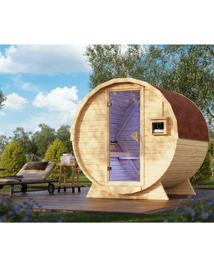 Moderne Fasssauna aus hellem Holz mit Glastür, lila Innenbeleuchtung und rotem Schindeldach, aufgestellt auf einer Holzterrasse im Garten neben einer Sonnenliege.