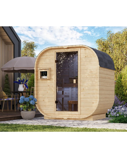 Moderne ovalförmige Gartensauna aus hellem Holz mit großer Glastür, externem digitalen Steuergerät und schwarzem Schindeldach, aufgestellt auf einer gepflasterten Terrasse im Garten.