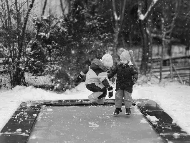 Kinder hüpfen auf dem Akrobat Primus Flat bei Schnee