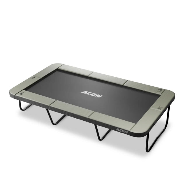 Freigestelltes ACON 16 HD Rechtecktrampolin mit schwarzer Sprungmatte, hellgrauer Schutzpolsterung und robusten Standbeinen.