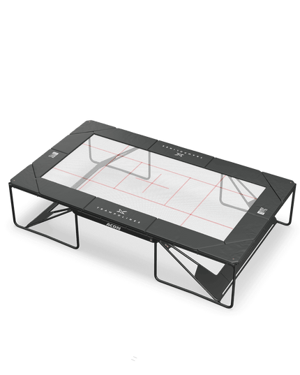 ACON X Wettkampf-Trampolin mit weißer Trampolinmatte, roten Orientierungslinien und schwarzer Schutzpolsterung.