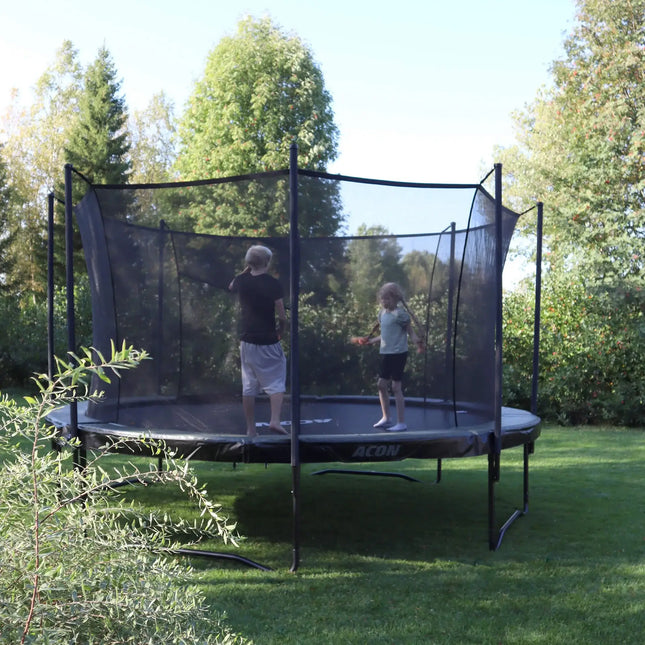 ACON AIR Gen 2.0 Rundtrampolin mit Sicherheitsnetz, auf dem zwei Kinder in einem grünen Garten spielen.