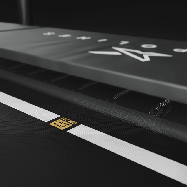 Nahaufnahme der schwarzen ACON X Sprungfläche mit weißer Sicherheitsmarkierung und goldfarbenem Safe-Mat-Symbol.